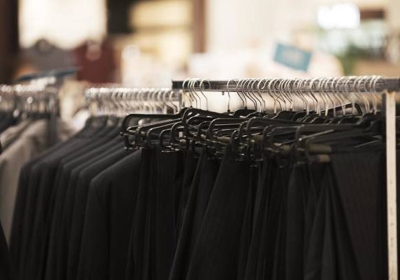 Black Suits and Pants on Hangers in a Clothing Store